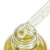 Zbliżenie pipety z płatkami złota nad otwartą butelką Yokaba 24k Gold Care Oil