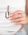 Butelka lakieru hybrydowego Makear 603 Milky French obok wystylizowanych paznokci, 8 ml