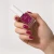 Dłoń z paznokciami pomalowanymi lakierem Yokaba 08 Charming Fushia i butelka lakieru