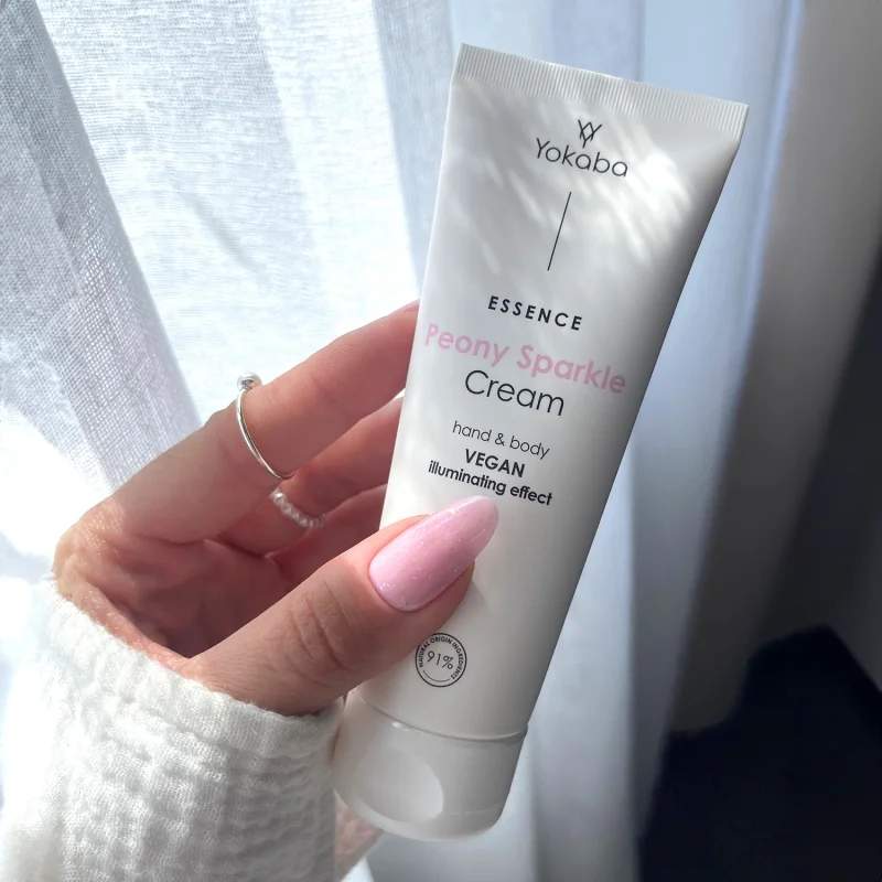 Tuba kremu Yokaba Peony Sparkle 75 ml trzymana w dłoni, etykieta hand & body vegan illuminating effect