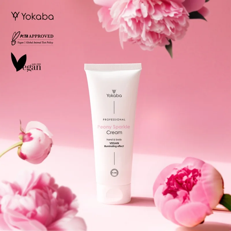Tuba Yokaba Peony Sparkle 75 ml wśród kwiatów peonii, obok oznaczenia PETA Approved i vegan