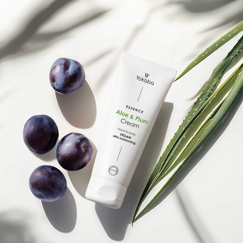 Tuba kremu Yokaba Aloe&Plum 75 ml wśród dojrzałych śliwek, obok liść aloesu