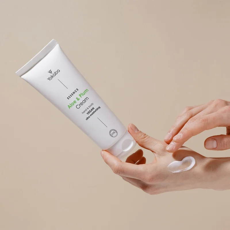 Krem Yokaba Aloe&Plum 75 ml rozsmarowany na wierzchu dłoni, tuba trzymana w ręce