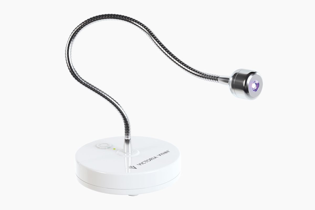 Lampa LED Victoria Vynn Soft Gel Tips ujęta pod kątem, wygięty wysięgnik i zapalona głowica nad podstawą