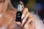 Lakier 475 Bellini Bianco z zestawu Victoria Vynn 5PACK Midnight Spritz, biały brokatowy manicure i butelka w dłoni