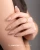 Makear lakier hybrydowy 966 - nude beż na migdałowych paznokciach, dłoń na ramieniu, 8 ml