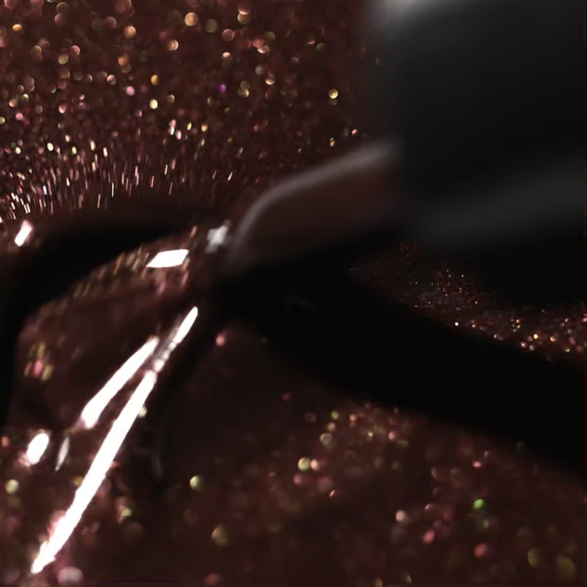 Tekstura lakieru hybrydowego Victoria Vynn 483 Gilded Ebony 8 ml, brąz ze złotą drobiną i pędzelek w zbliżeniu