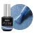 Elarto Top kocie oko i holo w jednym Catlight Denim 7ml - czarna butelka Dry Top ze srebrną nakrętką obok okrągłego kadru z pędzelkiem w niebieskim topie z holograficznymi drobinami