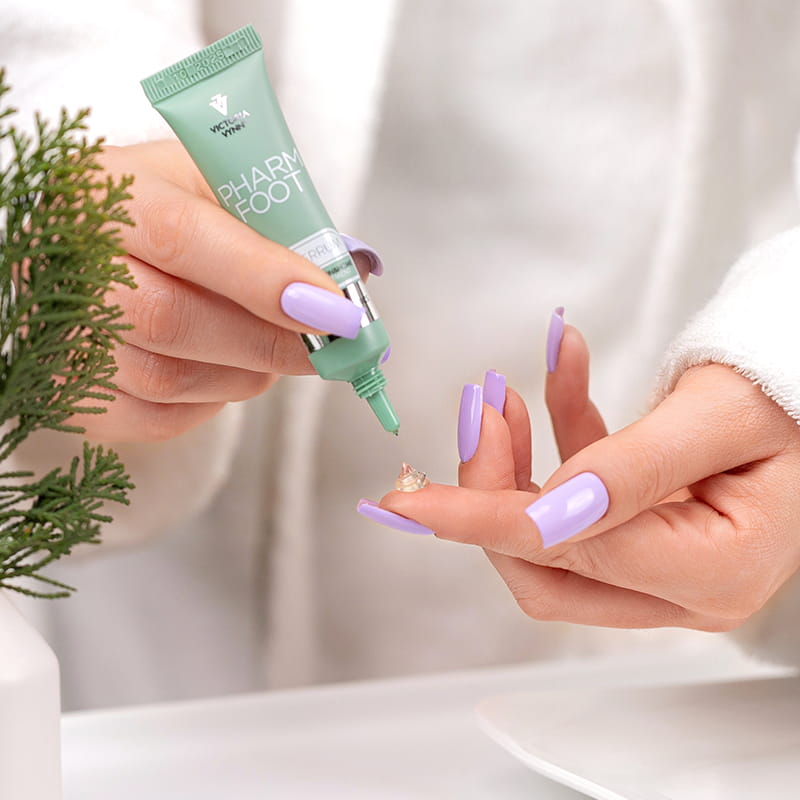 Kropla serum mycoVERRUM na palcu, tubka z wąską końcówką