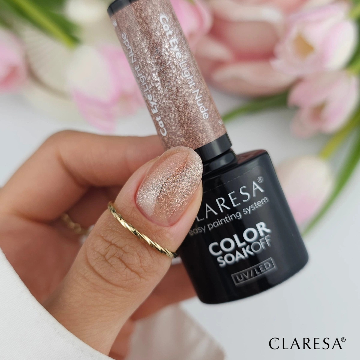 Claresa Nude Glow Cat Eye Light Nude - dłoń z butelką lakieru hybrydowego, paznokcie z magnetycznym efektem kociego oka