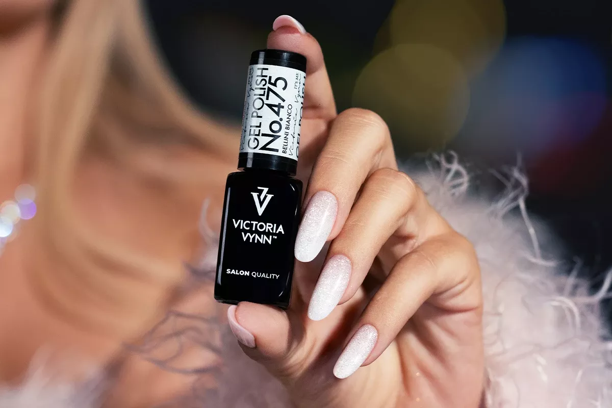 Biały brokatowy manicure lakierem Victoria Vynn 475 Bellini Bianco 8 ml, butelka trzymana w dłoni