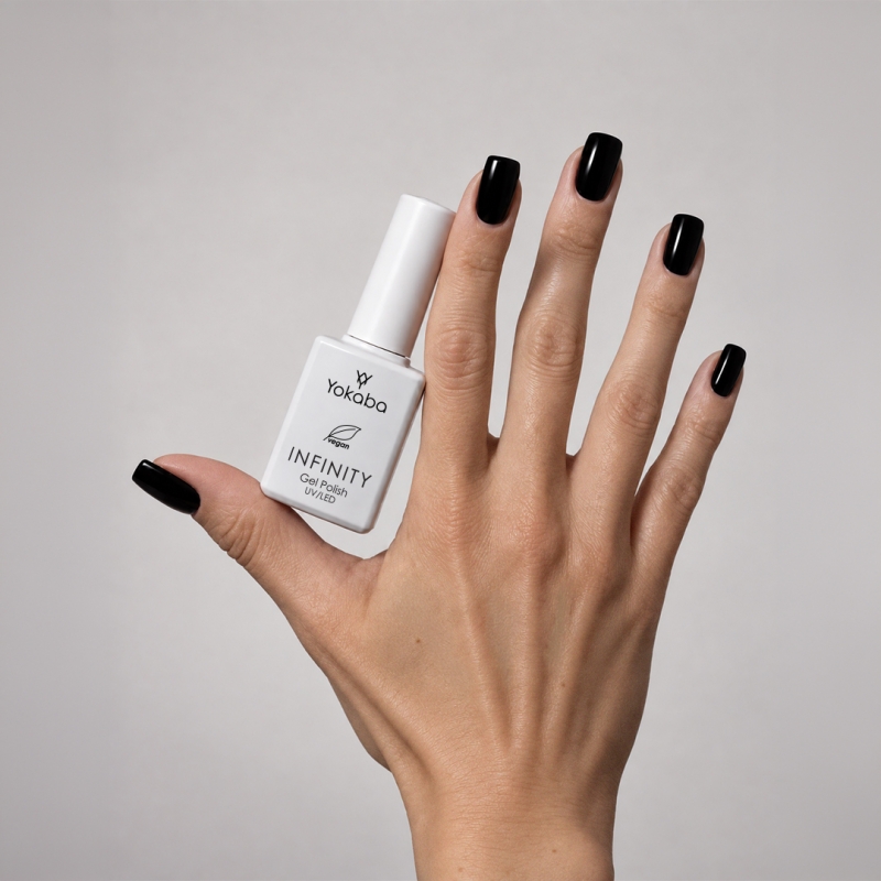 Lakier hybrydowy Yokaba Infinity 02 Black Diamond na paznokciach, dłoń z butelką