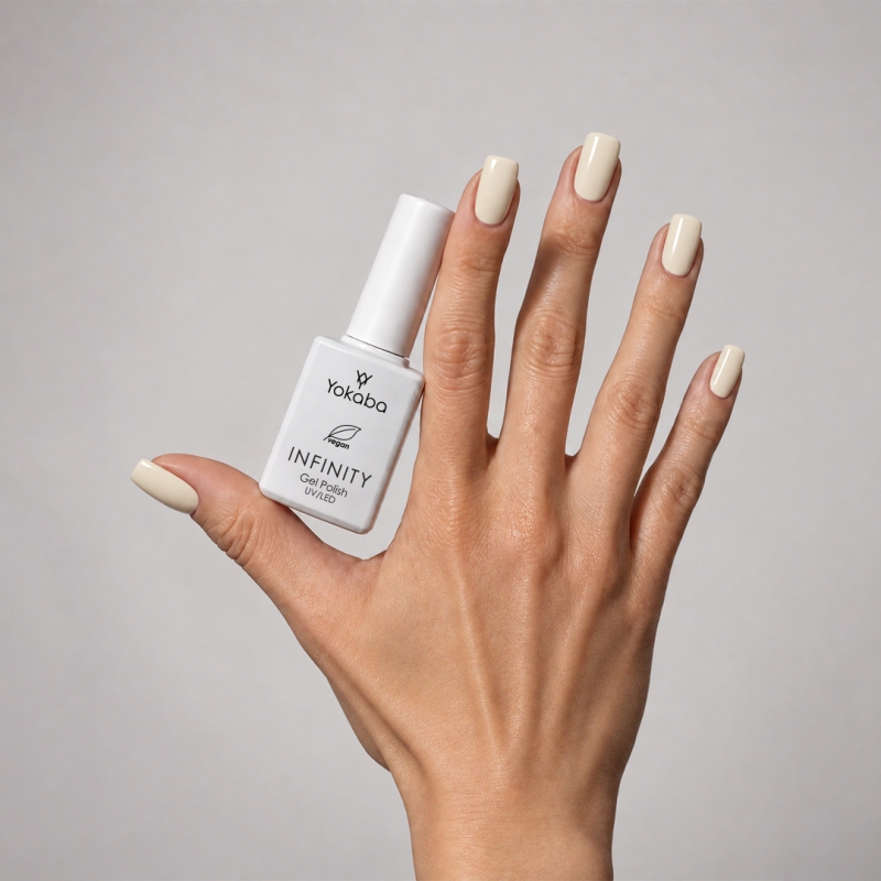 Lakier hybrydowy Yokaba Infinity 03 Vanilla Cream na paznokciach, dłoń z butelką