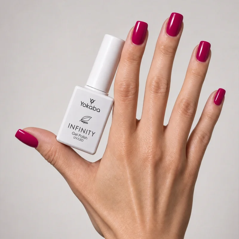 Lakier hybrydowy Yokaba Infinity 11 Magenta na paznokciach, dłoń z butelką
