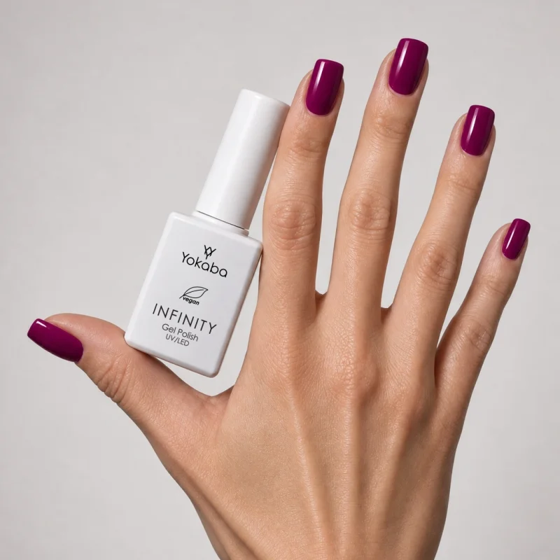 Lakier hybrydowy Yokaba Infinity 12 Orchid Crush na paznokciach, dłoń z butelką