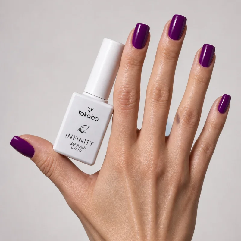 Lakier hybrydowy Yokaba Infinity 14 Imperial Plum na paznokciach, dłoń z butelką