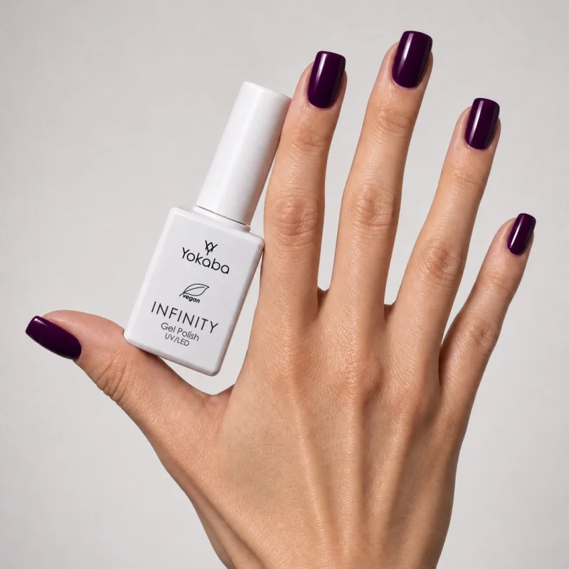 Lakier hybrydowy Yokaba Infinity 15 Purple Violet na paznokciach, dłoń z butelką